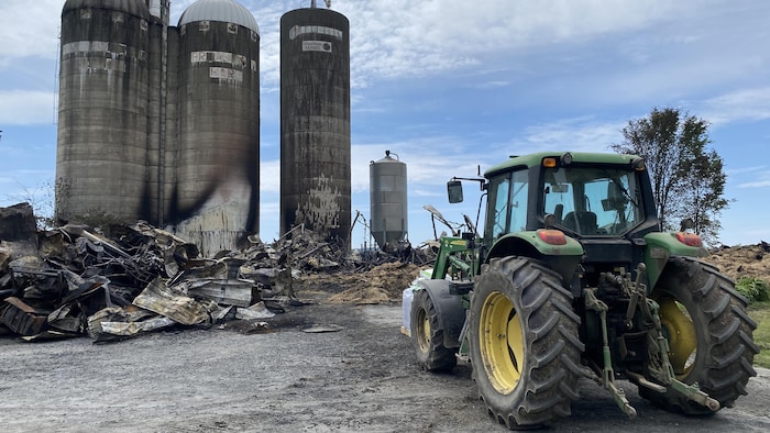Un bâtiment agricole rasé par des flammes, en morceaux brûlés.