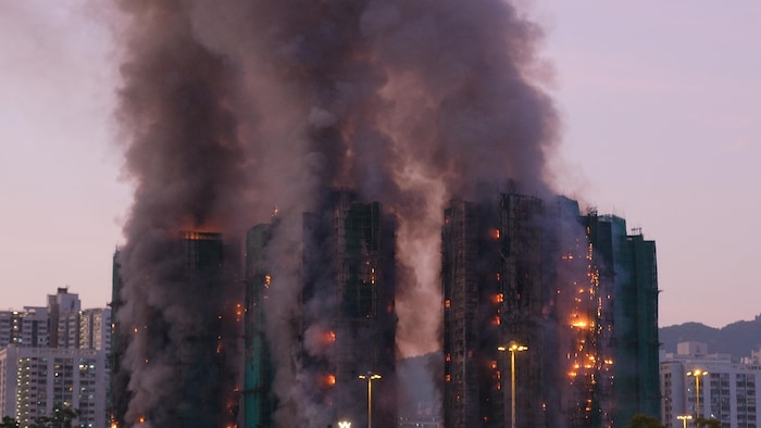 De la fumée s'échappe des tours incendiées à Hong Kong.