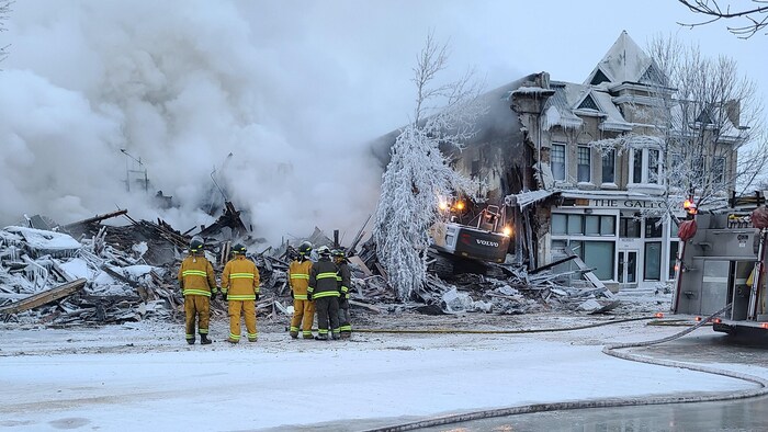 Des pompiers devant l'hôtel de Gladstone détruit par un incendie.  