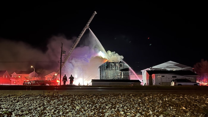 Des pompiers qui arrosent un immeuble. 