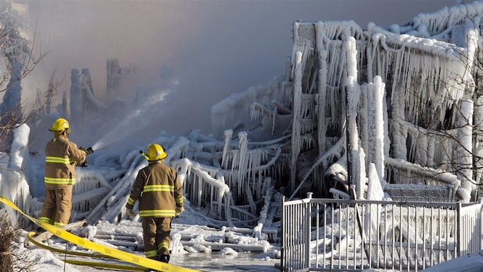 Pompiers devant les décombres de la Résidence du Havre de L'Isle-Verte, le 23 janvier 2014.