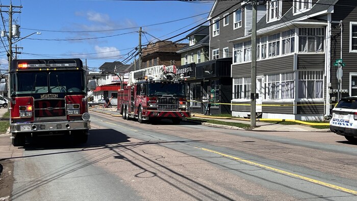 Deux camions de pompiers sont stationnés dans la rue.