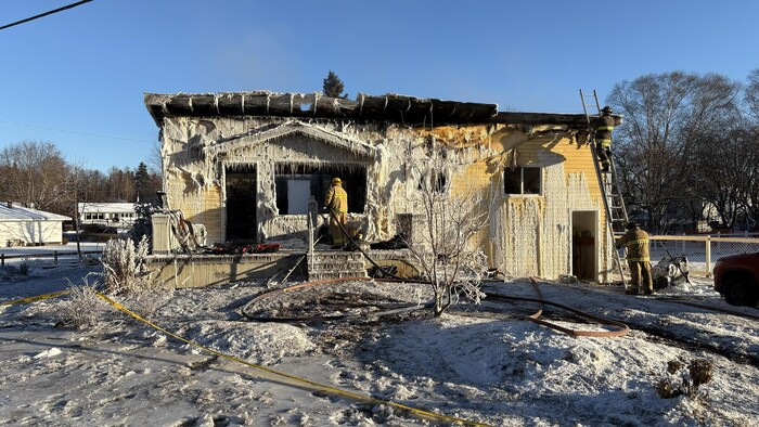 Une maison calcinée par les flammes. L'eau utilisée pour éteindre l'incendie a ensuite gelé sur la résidence.