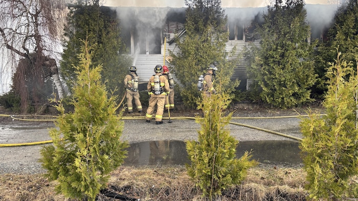 Des pompiers qui éteignent les flammes.
