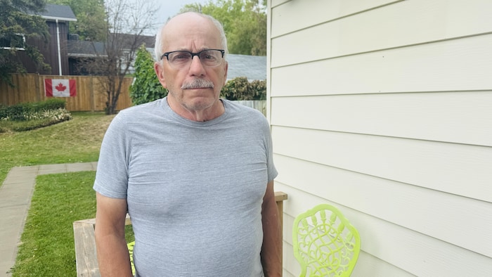 Un homme debout près d'une maison.