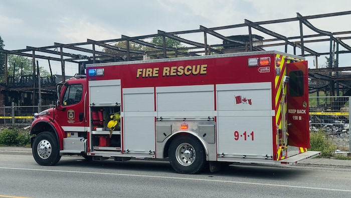 un véhicule de lutte contre l'incendie près d'un bâtiment pris par un feu.