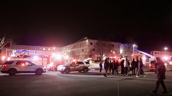 Two fire cranes surround a large building.