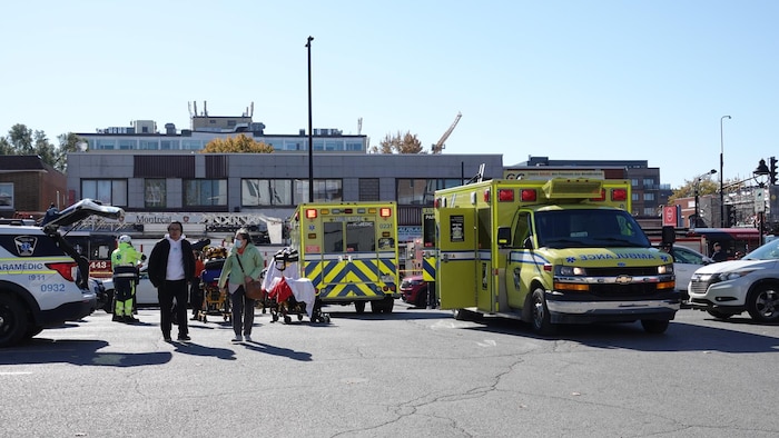 Des ambulances et des intervenants d'urgence devant un immeuble.