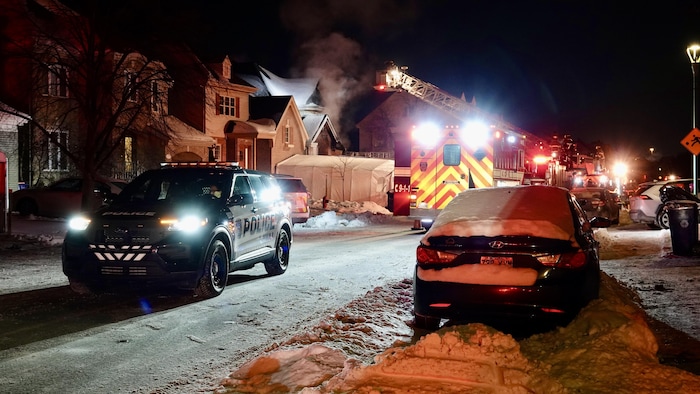 Les pompiers et les policiers sur les lieux d'un incendie, rue Edmond-Rostand, à Laval.