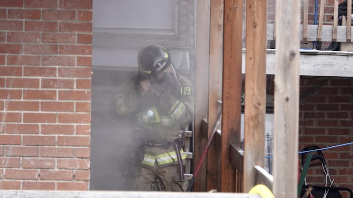 Un pompier met son masque lors d'une intervention à Sherbrooke.