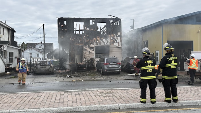 Des pompiers regardent une maison détruite par les flammes sur la 3e Avenue à Val-d'Or.