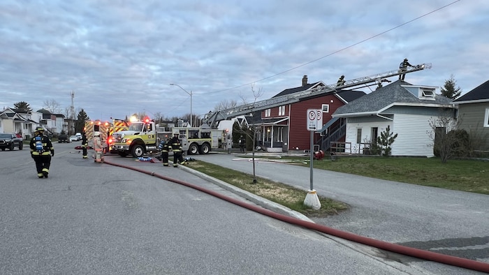 Une dizaine de pompiers travaillent à éteindre un incendie dans une résidence.