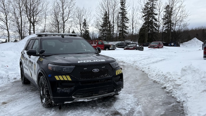 Une voiture de police est stationnée dans la neige.