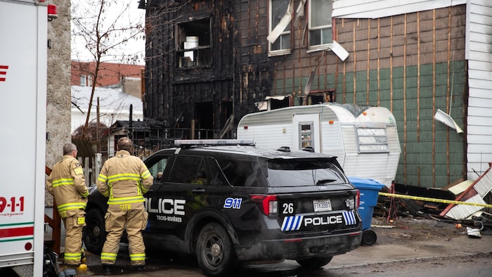 Des policiers et des pompiers sur les lieux de l'incendie.