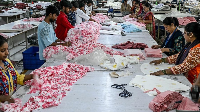 Des employés préparent des vêtements dans l'usine de fabrication de vêtements de Bhiwandi, dans le district de Thane, dans l'État indien du Maharashtra, le 30 juillet 2025.