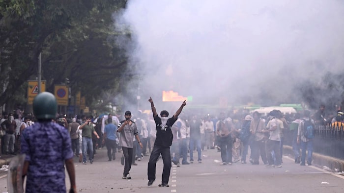 Des membres de la Force d'intervention rapide tirent des grenades lacrymogènes pour disperser les partisans du « parti des cafards » lors d'une manifestation.