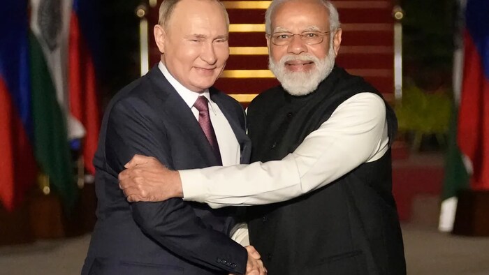 مصافحة حارة بين رئيس الحكومة الهندية ناريندرا مودي (إلى اليمين) وضيفه الرئيس الروسي فلاديمير بوتين في نيودلهي في 6 كانون الأول (ديسمبر) 2021. 
