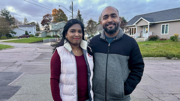 Le couple est debout dans une rue de Moncton. Ils sont souriants.