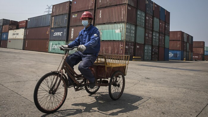 Un ouvrier passe devant des conteneurs dans un port en eau profonde des Philippines.