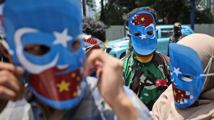 
Muslim students wearing masks with the colors of the pro-independence East Turkistan flag attend a rally outside the Chinese Embassy in Jakarta, Indonesia, earlier this year. The students staged the rally to call for an end to alleged oppression against the Muslim Uyghur ethnic minority in Xinjiang.