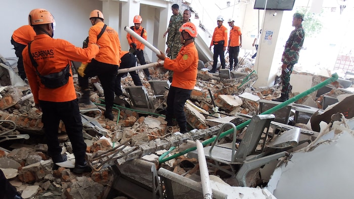 Une équipe de secours recherche des victimes dans les décombres du port Laurensius Say à Maumere, dans le district de Sikka, province de Nusa Tenggara oriental, le 15 août 2026, après qu'un séisme de magnitude 7,7 a frappé l'île de Flores.