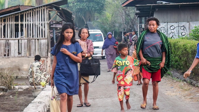 Des villageois fuient leurs maisons pour se mettre à l'abri après le séisme survenu le 15 août 2026 dans le village de Talibura, dans le district de Sikka, province de Nusa Tenggara oriental.