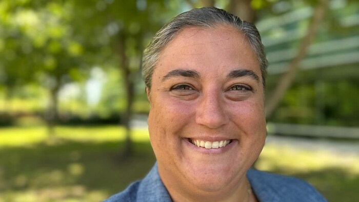 Mélissa Bouchard Viau souriante sous les arbres en été.