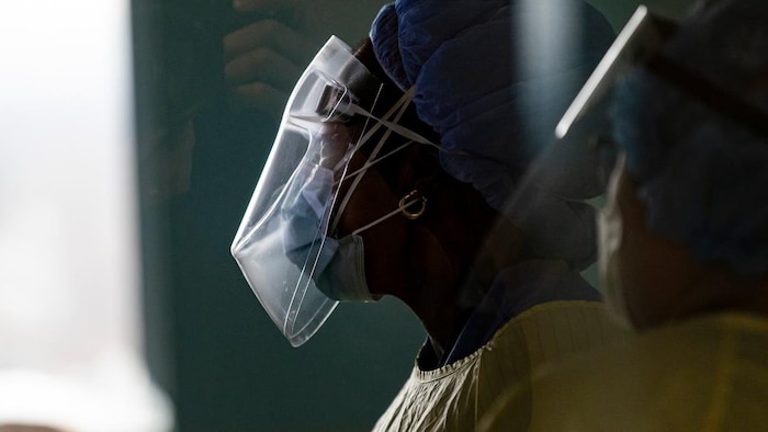 Deux infirmières portant des masques et visières. 