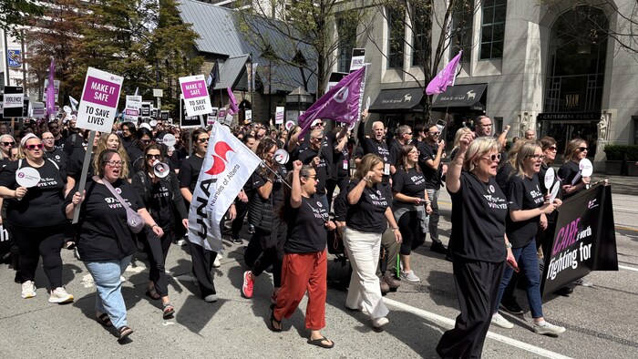 Des femmes tiennent des drapeaux et des pancartes et scandent des phrases de protestation.