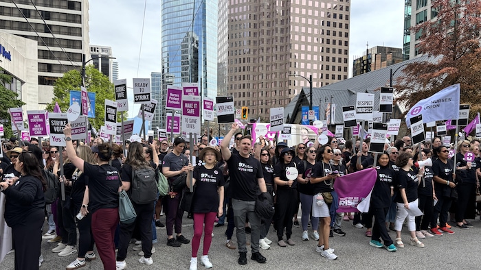 Des infirmières habillées en noir manifestent au centre-ville de Vancouver.