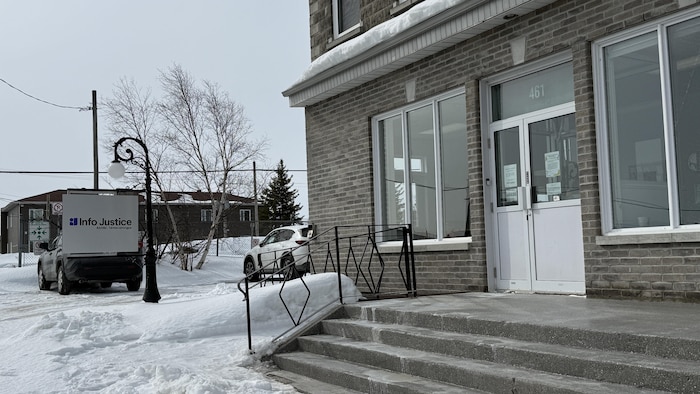 Immeuble avec une plaque en avant sur laquelle est écrit Info Justice. 