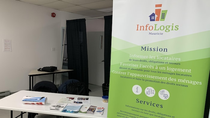 Une pancarte d'InfoLogis à côté d'une table avec des dépliants lors d'une séance d'information à Shawinigan.