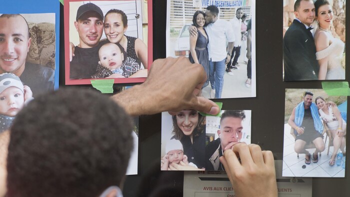 Personas colocan fotos de sus familiares en la puerta de una oficina de inmigración durante una manifestación contra los retrasos del gobierno en los certificados de reagrupación familiar en Montreal, el sábado 8 de agosto de 2020.