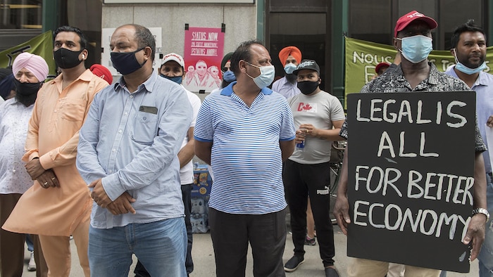 Manifestación frente a una oficina de inmigración en Montreal, el domingo 26 de julio de 2020, en la que se pide al gobierno que conceda el estatuto de residencia a todos los trabajadores inmigrantes con permisos de trabajo o sin ellos, y solicitantes de asilo. 