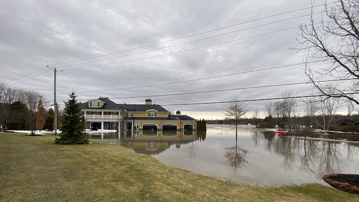 Une voiture et une maison touchées par les inondations.