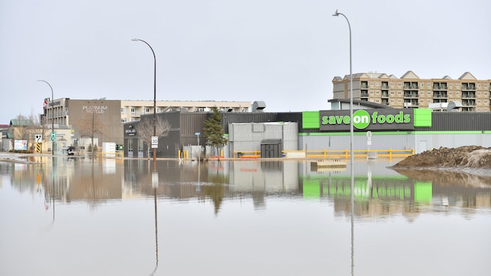 Une avenue de Fort McMurray sur laquelle on retrouve une épicerie, un restaurant et un hôtel est complètement inondée.