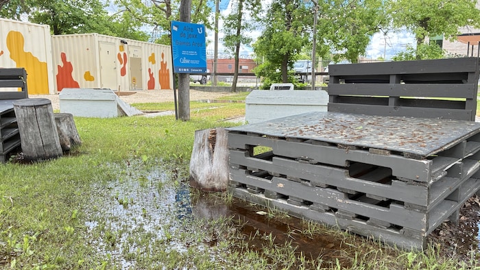 Le Patio 340 est sous les eaux. L'aire de jeux avec une banquette faite en palettes de bois est entourée d'eau et d’un peu de boue.