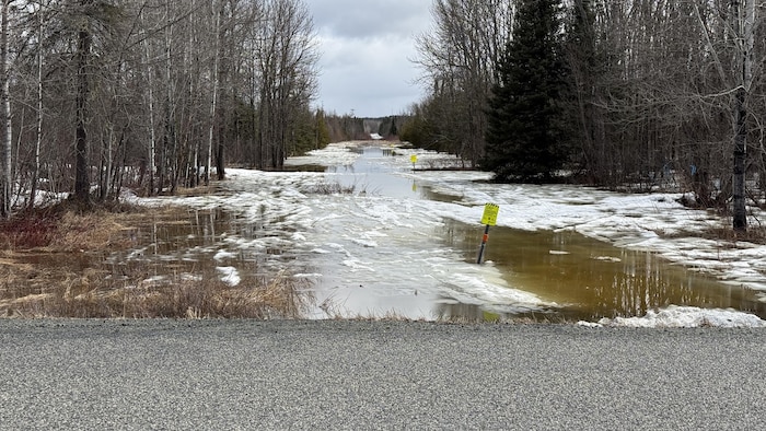 Le rang Lavigne est inondé. Des panneaux indiquent le passage sous terre d'une conduite de gaz.