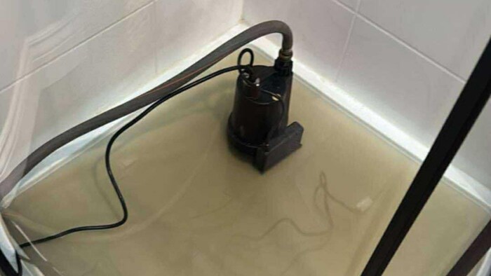 Une pompe dans une douche aspire l'eau usée.