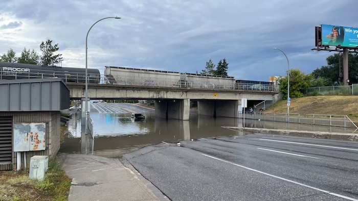 Une voiture coincée dans une inondation d'une rue.