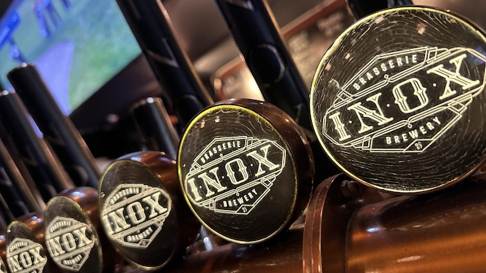 Poignées de fûts de bière affichant le logo d'Inox.