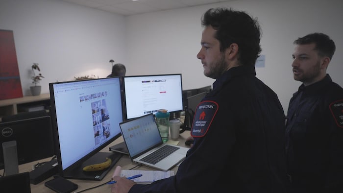 Des inspecteurs regardent un écran.