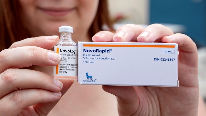 Une femme montre à la caméra une boîte rectangulaire et le flacon d'insuline qui se trouvait à l'intérieur.