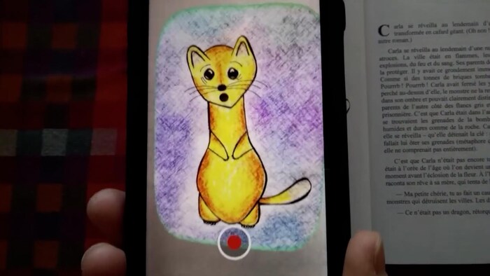 Apparition d'un chat sur un écran de de téléphone à partir d'une page de livre