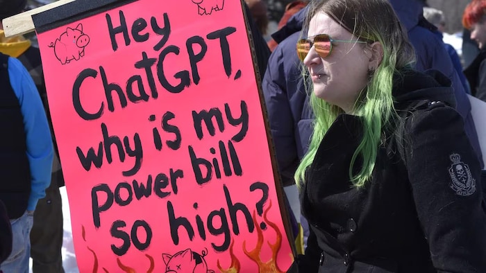 Une participante à une manifestation organisée en avril 2026 contre la construction d’un centre de données dédié à l’intelligence artificielle à Régina, en Saskatchewan.
