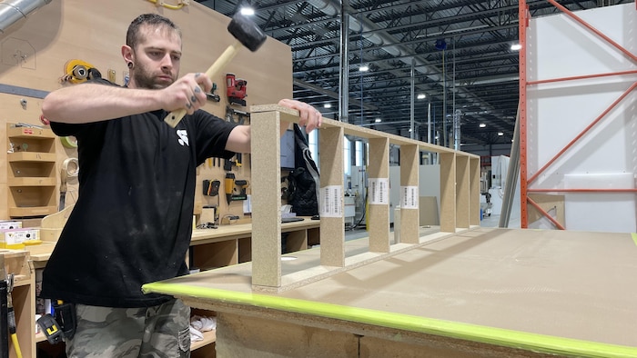 Un employé assemble un meuble