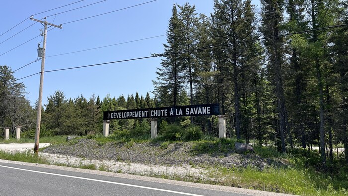 Une affiche qui indique le développement de Chute à la Savane.