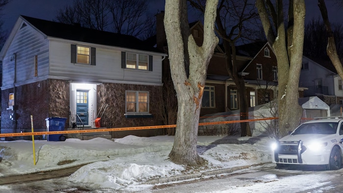Une voiture de police est garée devant une maison.