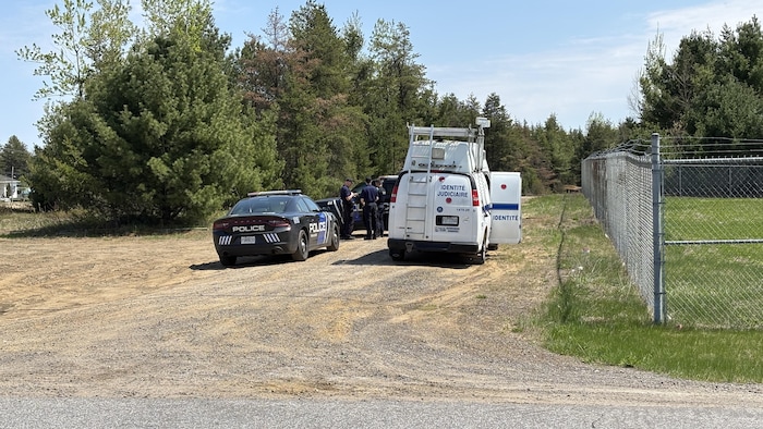 Des voitures de police et un fourgon d'identité judiciaire.