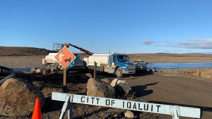 Des camions-citernes s'approvisionnent en eau au bord de la rivière Sylvia Grinnell, à Iqaluit.